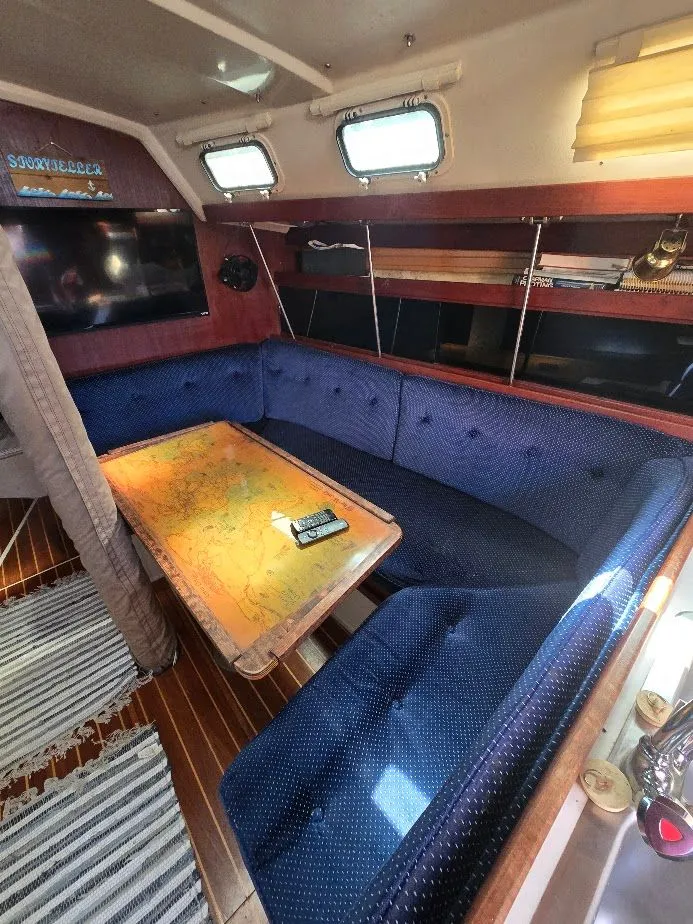 Slide: The Image of Interior of 1986 Catalina C-34 sailboat with blue seating and nautical map table. - 33