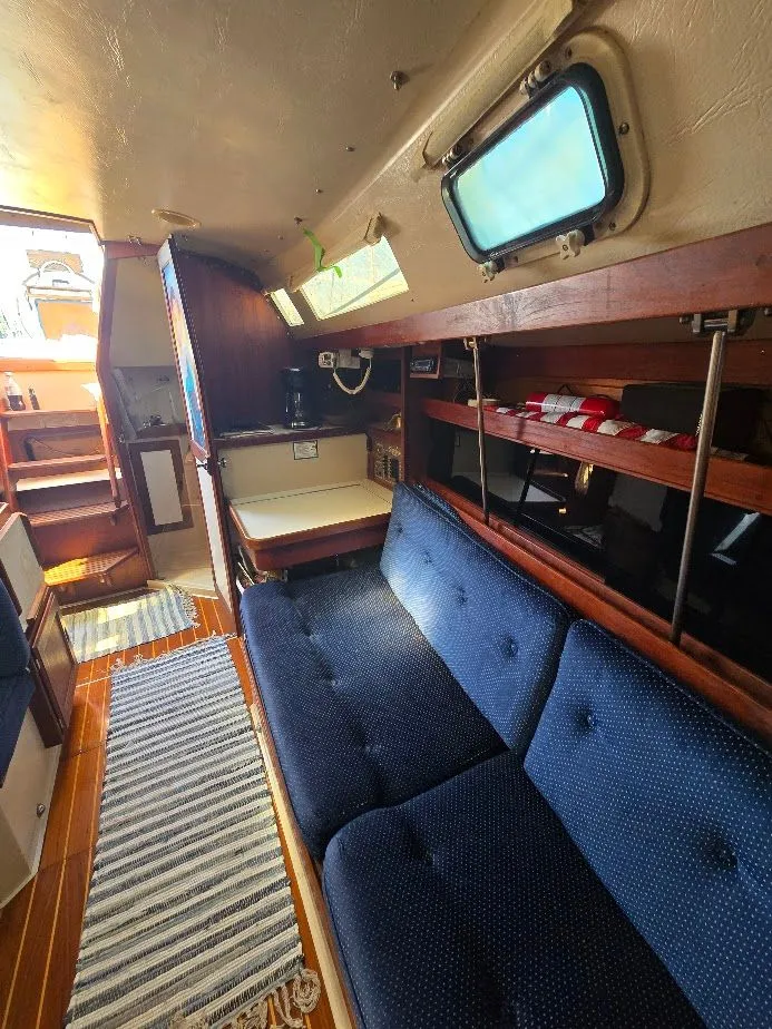 Slide: The Image of Interior of 1986 Catalina C-34 sailboat with blue seating and wooden accents. - 35