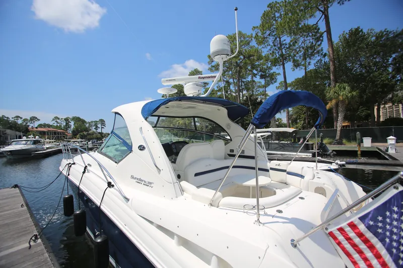 Slide: The Image of 2010 Sea Ray 390 Sundancer yacht docked at marina, featuring sleek design and American flag. - 5