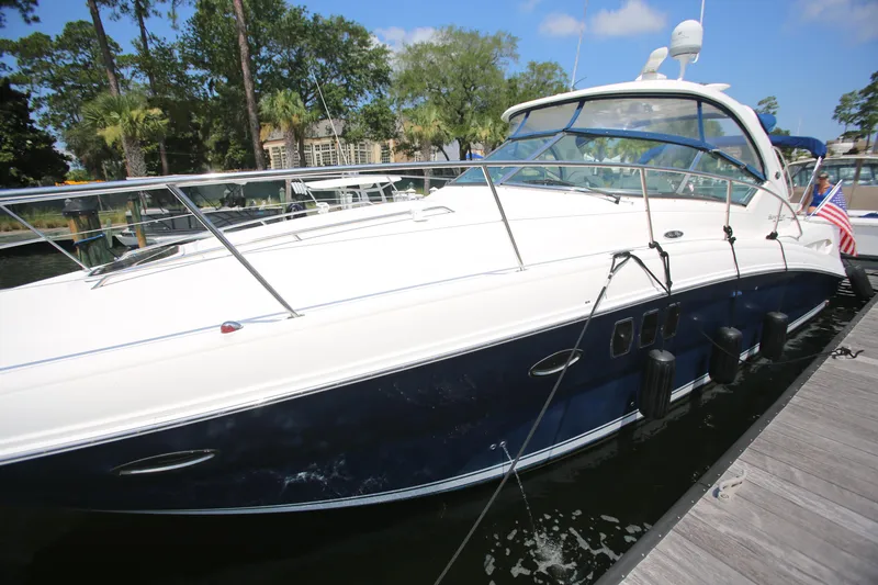 Slide: The Image of 2010 Sea Ray 390 Sundancer yacht docked at marina, sunny day, lush greenery background. - 6