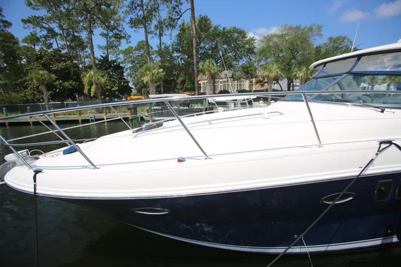 Slide: The Image of 2010 Sea Ray 390 Sundancer yacht docked by lush trees and clear sky. - 9