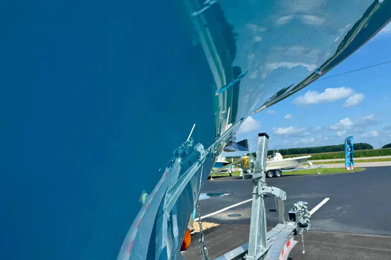Slide: The Image of 2025 Key West 291 FS boat on trailer, reflecting blue sky and clouds. - 11