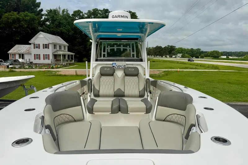Slide: The Image of 2025 Key West 291 FS boat with luxurious seating, parked near a rural house. - 14
