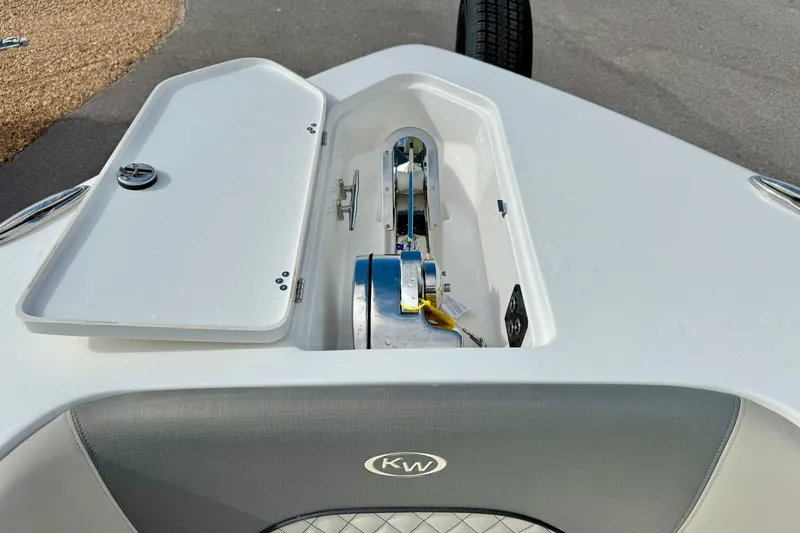 Slide: The Image of 2025 Key West 291 FS boat anchor compartment with open hatch, showcasing storage and winch. - 19