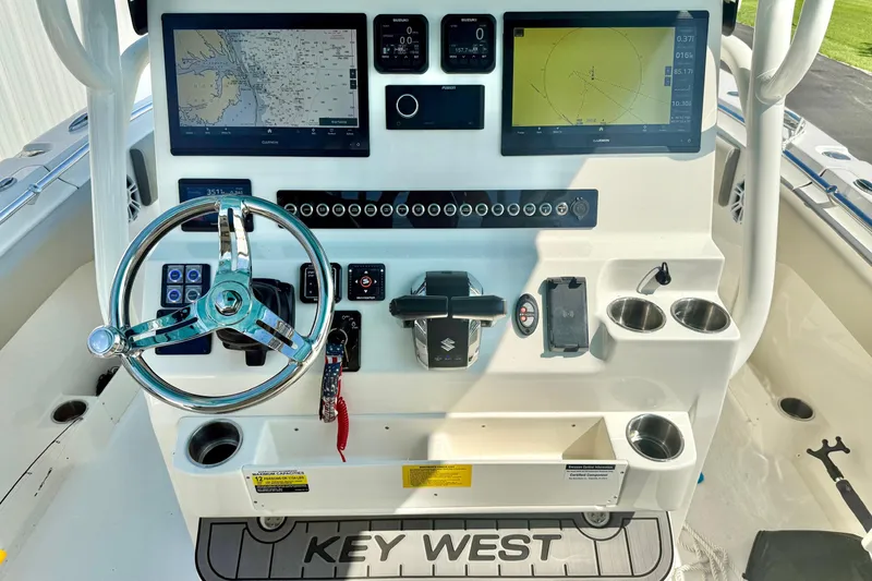 Slide: The Image of 2025 Key West 291 FS boat dashboard with steering wheel and navigation screens. - 33