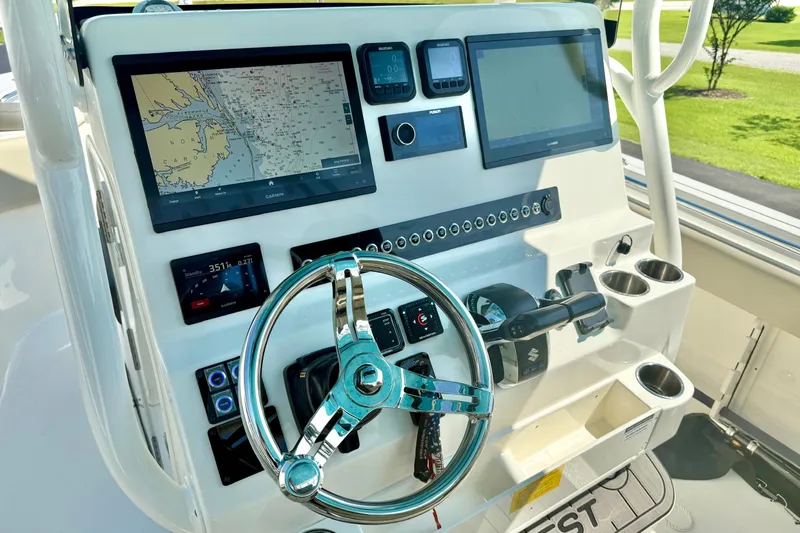 Slide: The Image of 2025 Key West 291 FS boat dashboard with navigation screens and steering wheel. - 35