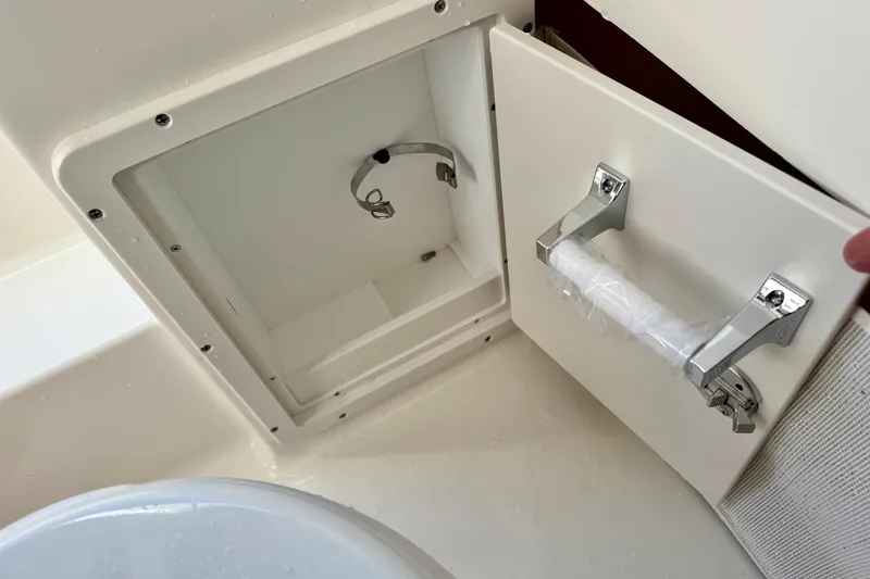 Slide: The Image of Open storage compartment on 2025 Key West 291 FS boat, featuring a secure latch and handle. - 46