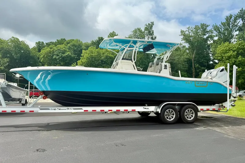 Slide: The Image of 2025 Key West 291 FS boat on trailer, vibrant blue hull, parked outdoors. - 5
