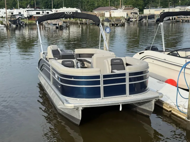 Slide: The Image of 2024 Harris Cruiser 230 pontoon boat docked at a marina. - 3