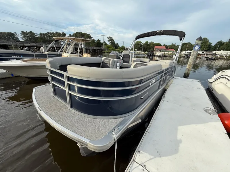 Slide: The Image of 2024 Harris Cruiser 230 pontoon boat docked at marina, featuring sleek design and spacious seating. - 4