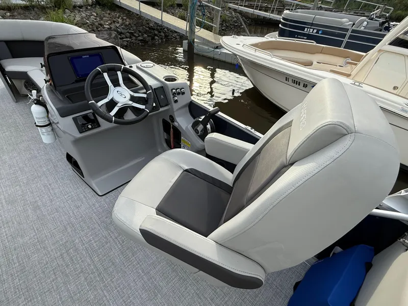 Slide: The Image of 2024 Harris Cruiser 230 boat interior with steering wheel and captain's chair. - 7