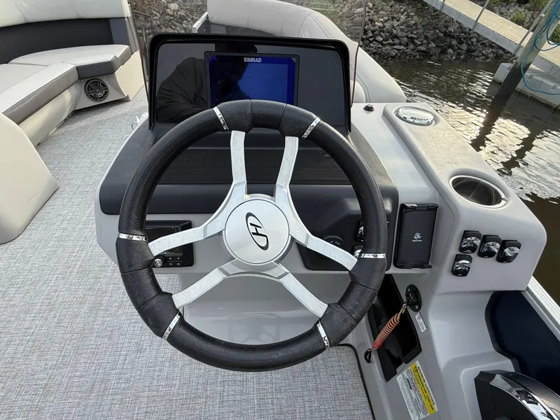 Slide: The Image of Steering wheel of 2024 Harris Cruiser 230 boat with control panel and navigation screen. - 8