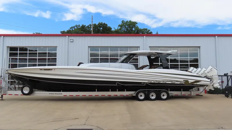 The Image of 2022 MTI 50v boat on trailer outside a garage, featuring sleek design and multiple engines. - 0