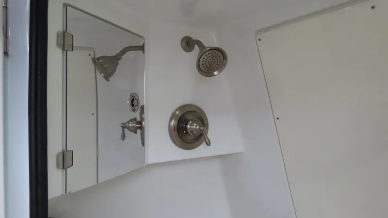 Slide: The Image of Compact shower area with stainless steel fixtures in a 2022 MTI 50v model. - 13