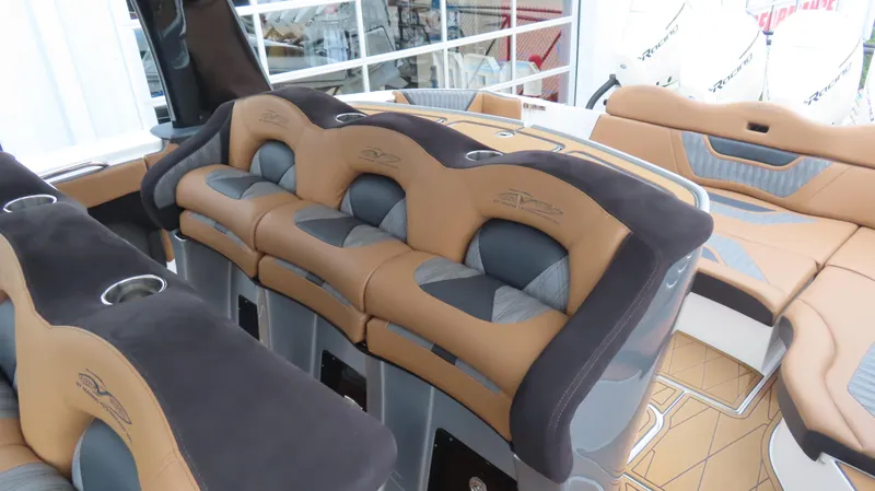 Slide: The Image of Luxurious seating on 2022 MTI 50v boat, featuring tan and gray upholstery with cup holders. - 22