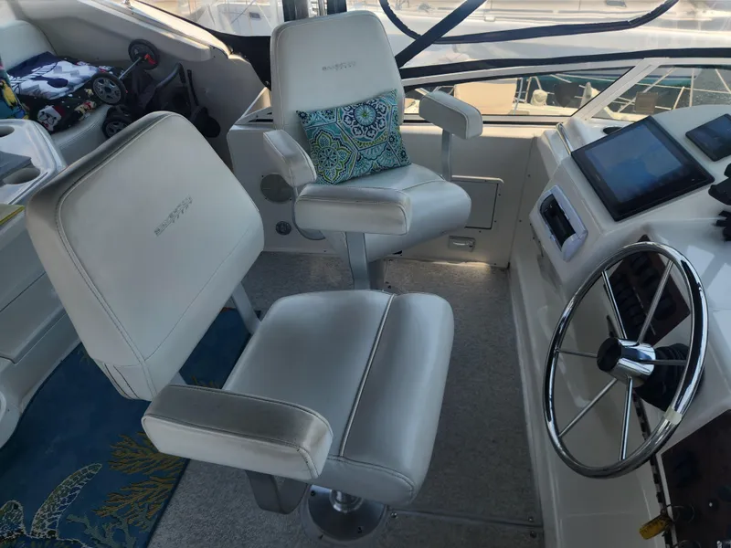 Slide: The Image of Captain's chairs and helm of 2000 Silverton 453 Motor Yacht, featuring modern controls and steering wheel. - 10