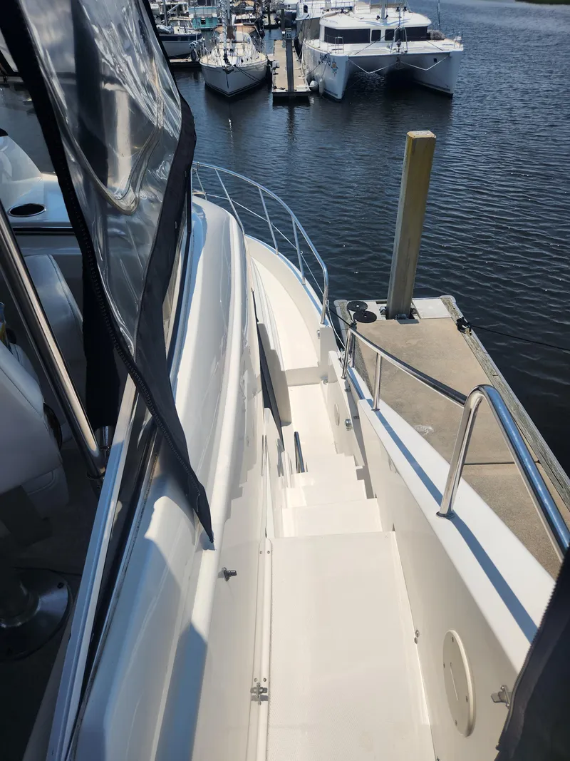 Slide: The Image of 2000 Silverton 453 Motor Yacht docked at marina, view of deck and surrounding boats. - 27