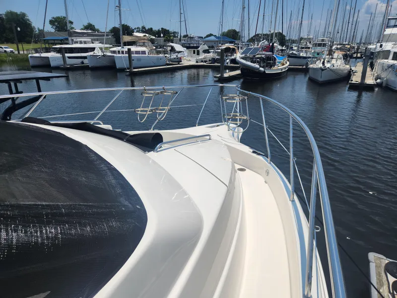 Slide: The Image of 2000 Silverton 453 Motor Yacht docked in a marina, surrounded by sailboats. - 29