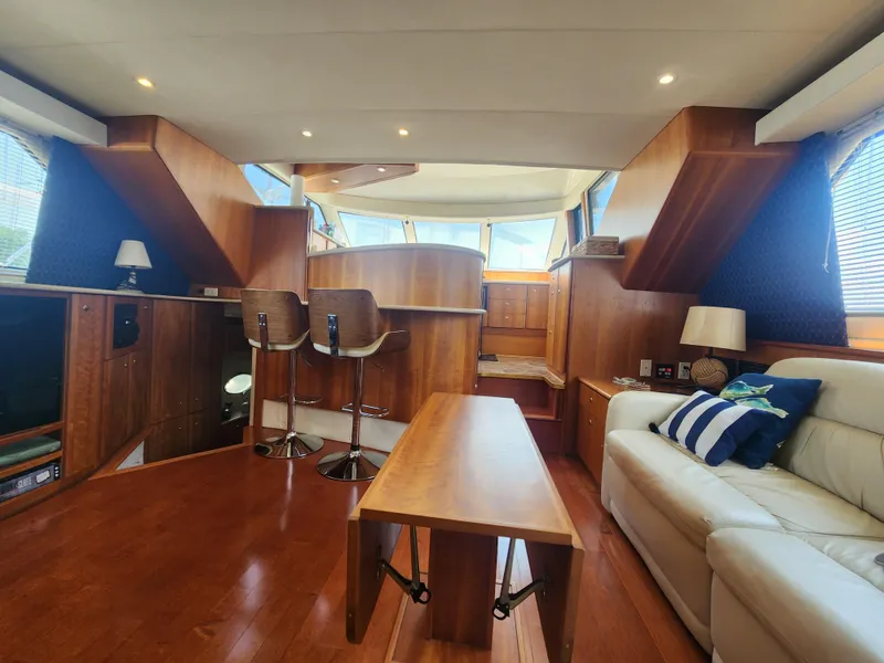 Slide: The Image of Interior of 2000 Silverton 453 Motor Yacht with wooden furnishings and cozy seating area. - 35
