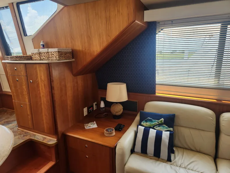 Slide: The Image of Interior of 2000 Silverton 453 Motor Yacht with wooden cabinetry and bar stools. - 44