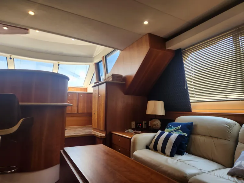 Slide: The Image of Interior of 2000 Silverton 453 Motor Yacht with wooden cabinetry and bar stools. - 45