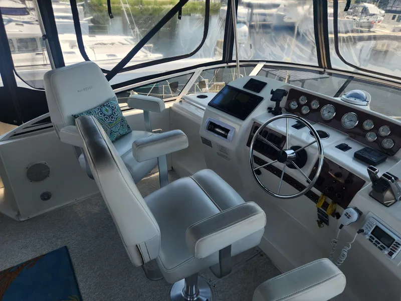 Slide: The Image of Interior of 2000 Silverton 453 Motor Yacht cockpit with steering wheel and control panel. - 7