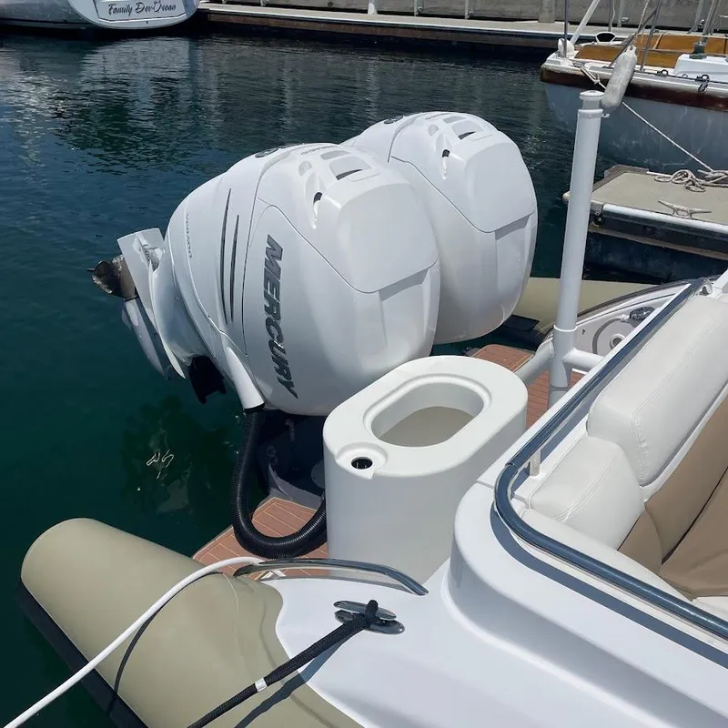 Slide: The Image of Twin Mercury outboard engines on a 2016 Airship 330 boat, docked in calm waters. - 3