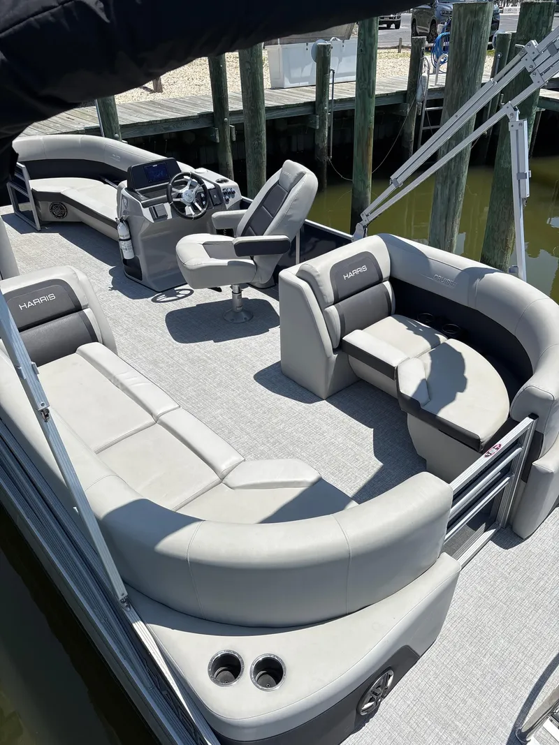 Slide: The Image of 2024 Harris Cruiser 230 pontoon boat with spacious seating and modern helm. - 1