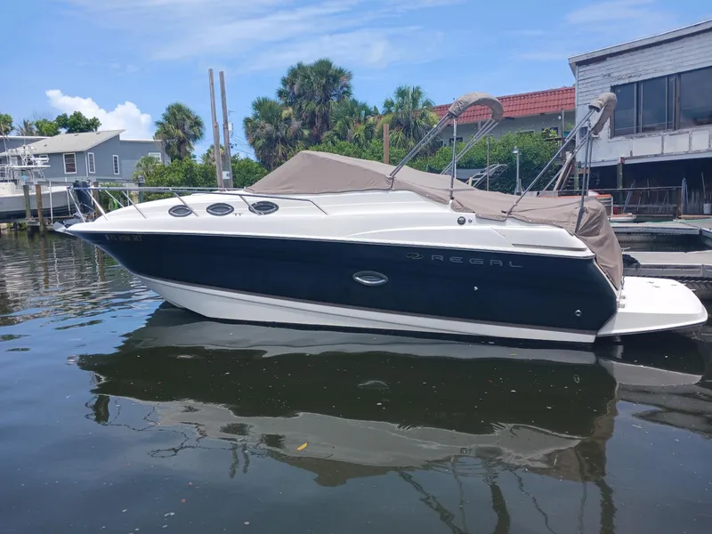 The Image of 2004 Regal 2760 Commodore boat docked on calm water, covered and ready for use. - 0