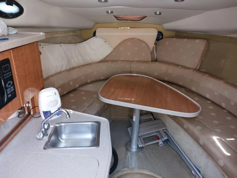 Slide: The Image of Interior of 2004 Regal 2760 Commodore boat with kitchenette and seating area. - 10