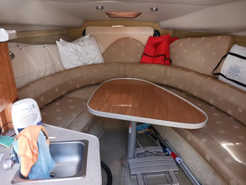 Slide: The Image of Interior of 2004 Regal 2760 Commodore boat with seating, table, and sink. - 11