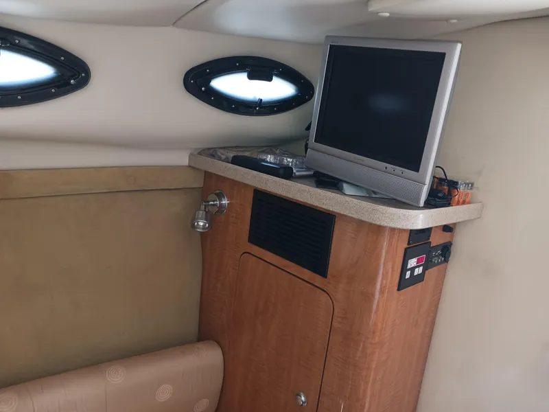 Slide: The Image of Interior of 2004 Regal 2760 Commodore boat with TV and wooden cabinetry. - 13