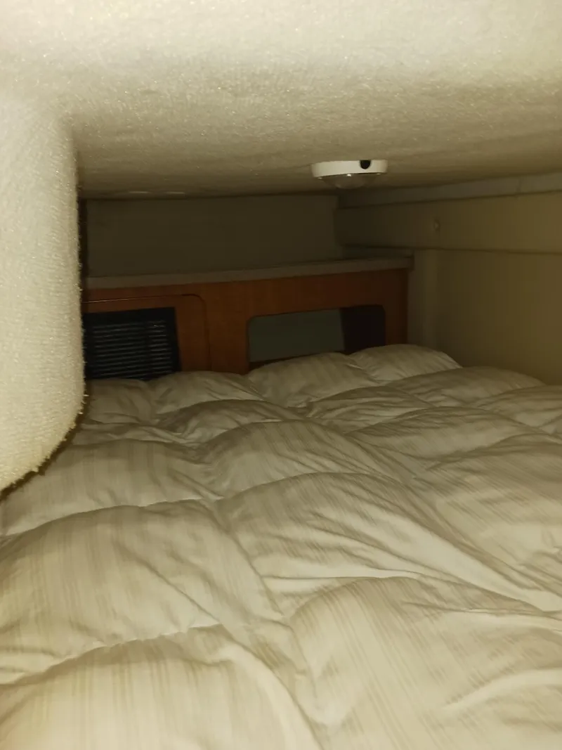 Slide: The Image of Cozy cabin interior of 2004 Regal 2760 Commodore boat with cushioned bedding. - 15