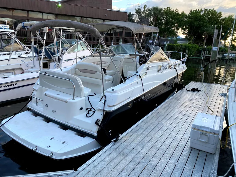 Slide: The Image of 2004 Regal 2760 Commodore boat docked at marina, surrounded by other vessels. - 2