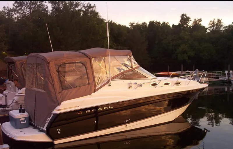 Slide: The Image of 2004 Regal 2760 Commodore boat docked at sunset, featuring a covered cabin. - 21