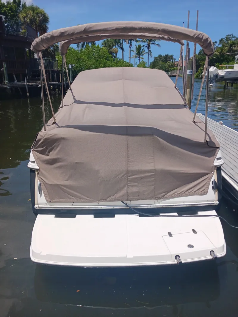 Slide: The Image of 2004 Regal 2760 Commodore boat covered at dock, sunny day, calm water. - 25