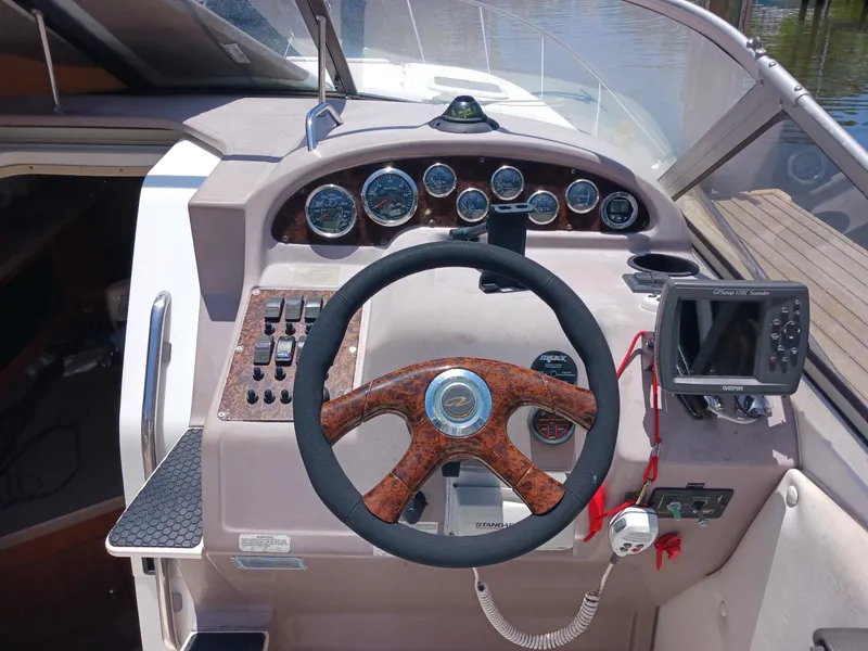 Slide: The Image of 2004 Regal 2760 Commodore boat dashboard with steering wheel and navigation instruments. - 8
