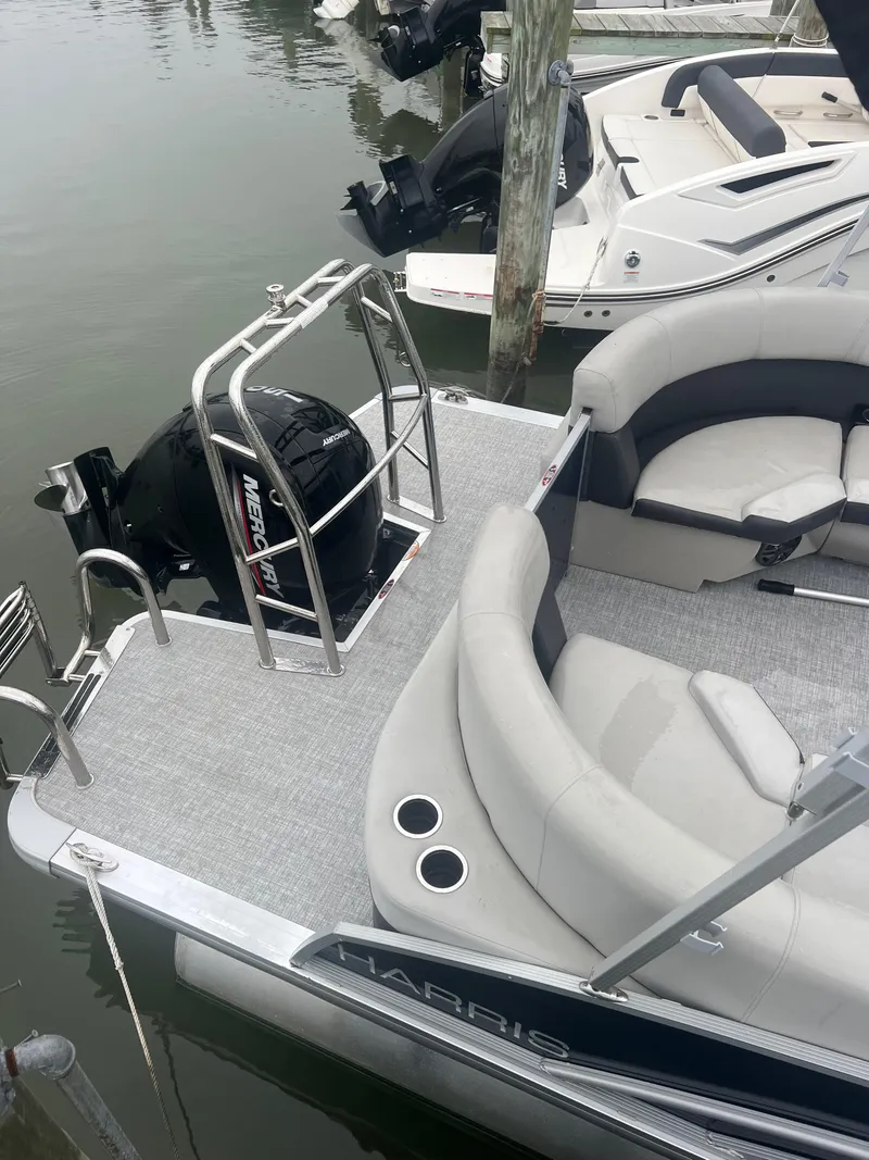 Slide: The Image of 2024 Harris Cruiser 230 pontoon boat with Mercury engine, docked at marina. - 11