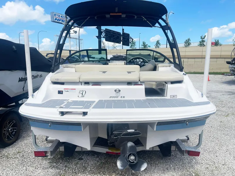 Slide: The Image of 2021 Regal 2000 ES Bowrider boat, rear view, parked on gravel, under blue sky. - 4