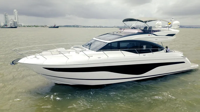 Slide: The Image of Luxurious 2020 Princess S62 yacht cruising on calm waters under cloudy skies. - 16