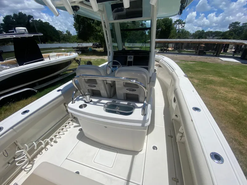 Slide: The Image of 2022 Boston Whaler 250 Outrage boat interior with helm and seating, under sunny skies. - 10