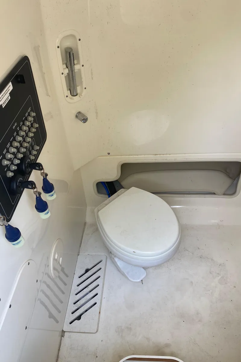 Slide: The Image of 2022 Boston Whaler 250 Outrage boat interior with toilet and control panel. - 18