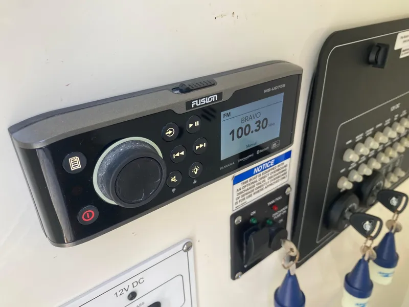 Slide: The Image of 2022 Boston Whaler 250 Outrage boat dashboard with Fusion marine radio and control panel. - 19