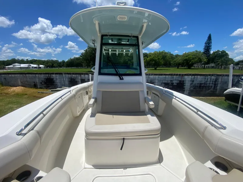 Slide: The Image of 2022 Boston Whaler 250 Outrage boat interior with seating, under a clear blue sky. - 23