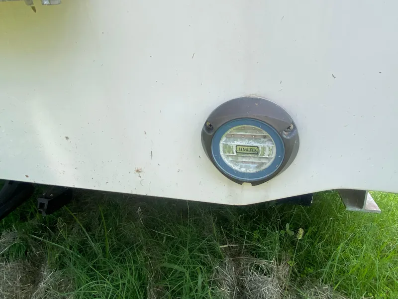 Slide: The Image of 2022 Boston Whaler 250 Outrage with Lumitec light on hull, resting on grass. - 6