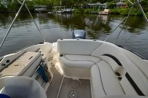 Slide: The Image of 2011 Sea Ray 240 Sundeck boat interior with seating, on a calm river. - 12