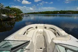 Slide: The Image of 2011 Sea Ray 240 Sundeck boat on calm lake with lush greenery and blue sky. - 9