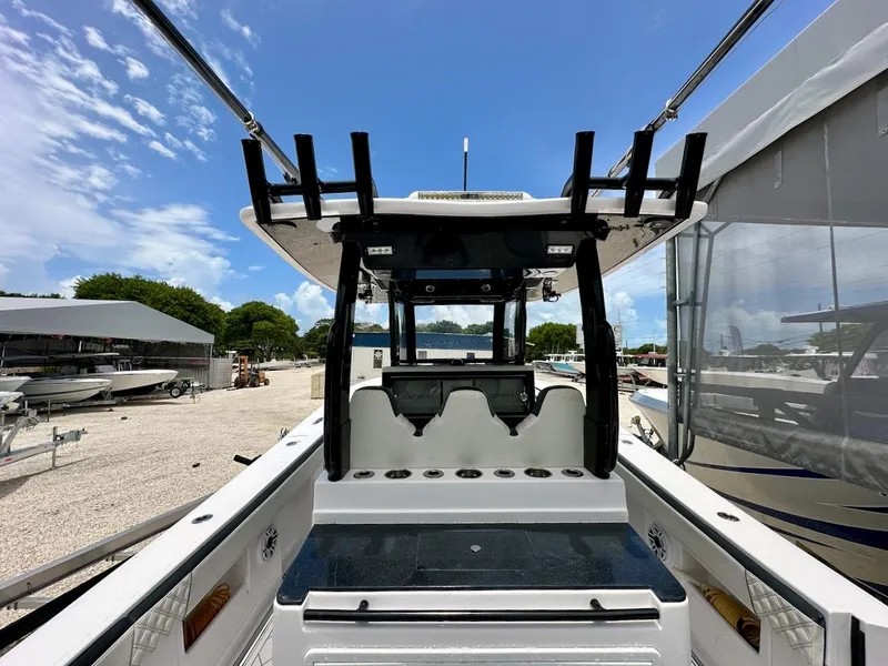 Slide: The Image of 2021 Streamline 35CC boat interior with rod holders and seating, under a clear blue sky. - 15