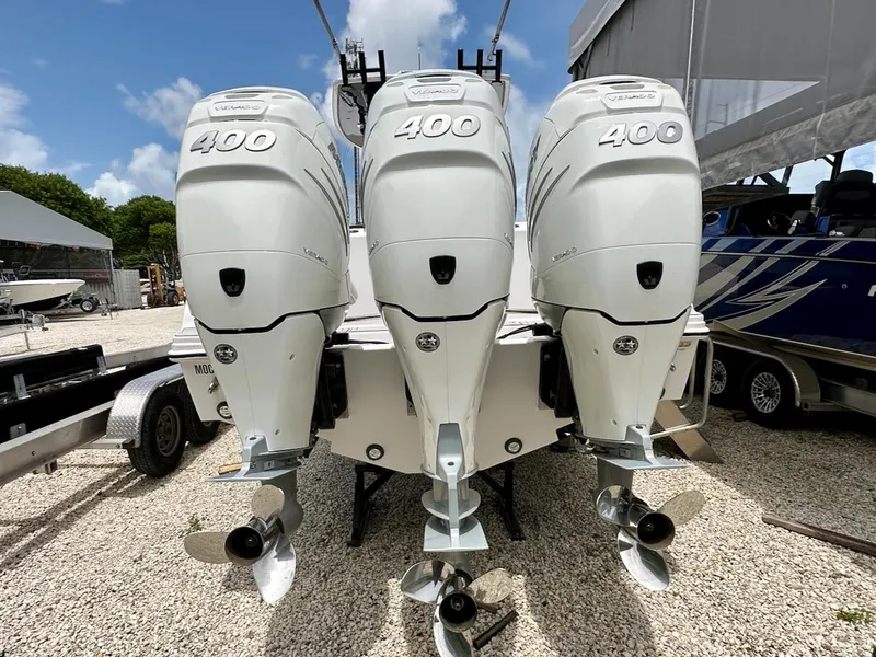 Slide: The Image of Triple 400 horsepower outboard engines on a 2021 Streamline 35CC boat, parked on gravel. - 2