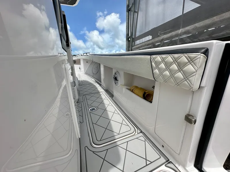 Slide: The Image of 2021 Streamline 35CC boat interior with quilted upholstery and storage compartments under a blue sky. - 23